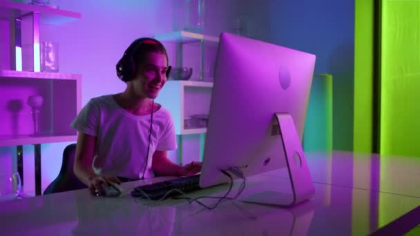 Cyber streamer talking online with team closeup. Neon joyful player in headset — Wideo stockowe