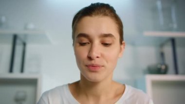 Gülümseyen kadın bilgisayarın yakın çekimini kullanarak webcam 'e bakıyor. Uygulama kullanıcı yazıcı sohbeti