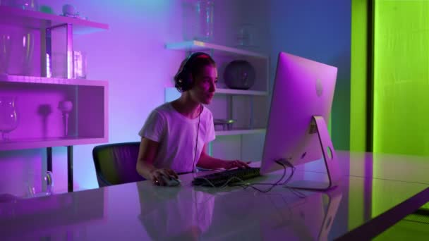 Cyber girl celebrating victory in neon gaming room closeup. Happy woman winner — Wideo stockowe