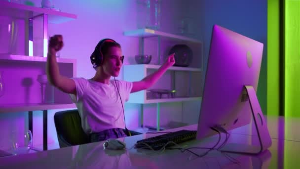 Beautiful gamer winning esport competition online in neon lights at home closeup — Stock video