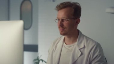 Hekim, aşı şişesini hastanede tutuyor. Doktor adam sıvıyı inceliyor..