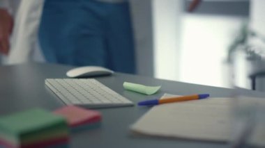 Doktor yakın planda bilgisayarını kullanarak masaüstünde oturuyor. Klinikte Teknoloji