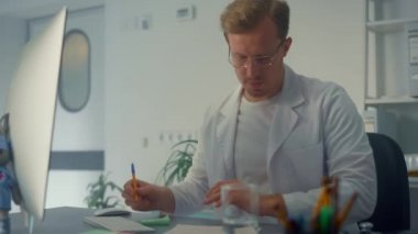 Ciddi bir doktor hastaneyi kapatıyor. Adam doktor çevrimiçi bilgisayar kullanıyor.