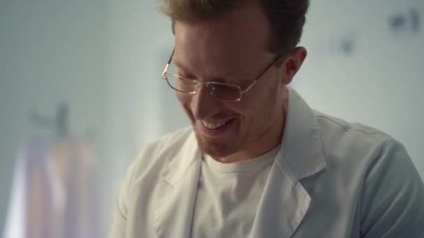Porträt lächelnder Arzt in der Sprechstunde im Krankenhaus. Arzt spricht Patient an — Stockvideo