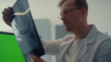 Doktor X-ray akciğerlerini kontrol ediyor. Krom anahtar ekranı kullanarak danışmanlık yapıyor..