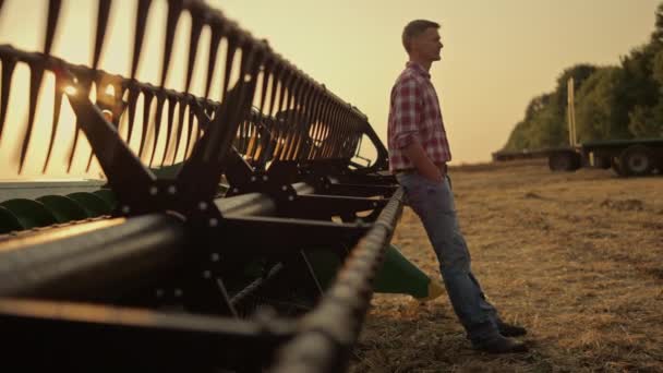 Lantbrukare slappna av gyllene fält på kombinera skördare ensam. Affärsidé inom jordbruket — Stockvideo