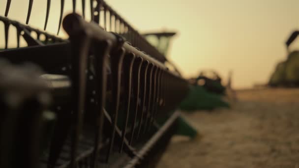 Silhueta agricultor stand máquinas equipamentos ao pôr do sol. Colheitadeira facas de perto — Vídeo de Stock
