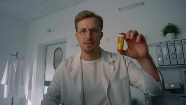 Terapeuta sosteniendo botella píldora en consulta en línea en la clínica de salud de cerca. — Vídeos de Stock