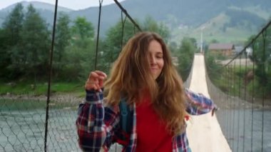 Pozitif otostopçu dağ tatilinde dans etmekten hoşlanır. Kadın ellerini dışarı çıkar.