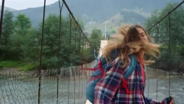 Touristen springen Bergbrücke auf Urlaubstour. Schöne Wanderin tanzt draußen — Stockvideo