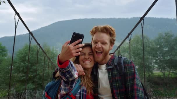 Turistler dağlarda video çekmek için seyahat ederler. Cep telefonundan selfie çeken bir çift. — Stok video