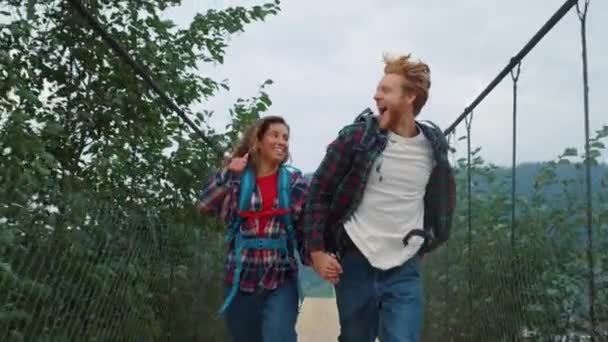 Dois mochileiros correndo natureza no campo de montanha. Sorrindo casal segurar as mãos — Vídeo de Stock