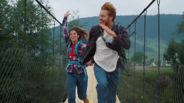 Emocionální pár poutníků na horském mostě. Turisté závodí rychle venku — Stock video