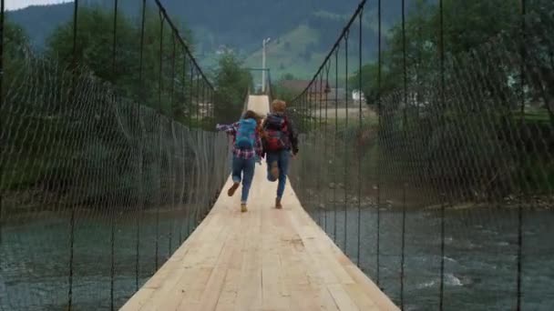 在自然河上有几座高山桥。兴奋的游客在外面玩的开心. — 图库视频影像