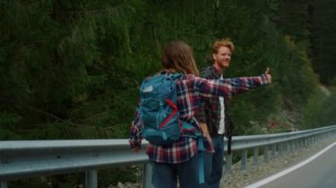 Gezginler dağlarda birlikte otostop yapıyorlar. Yolda çift olarak başparmak kaldırıyoruz..