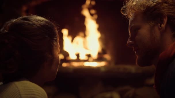 可爱的夫妻在温暖的房子里享受约会。浪漫的情人们放松地坐在壁炉边. — 图库视频影像