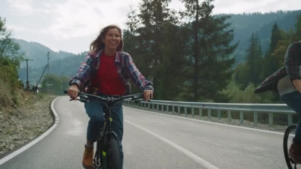 Casal desfrutando de passeio de bicicleta nas montanhas. Ciclistas que se exercitam na estrada florestal. — Vídeo de Stock