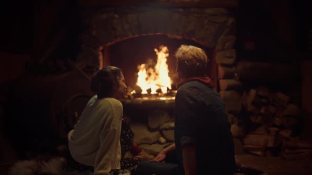 Köy evinde şömine başında oturan romantik bir çift. İki aşık sıcak evin tadını çıkarır.. — Stok video