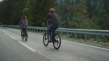 Çift dağ yolunda bisiklet gezisinden hoşlanıyor. Yolda bisiklet süren iki motorcu..