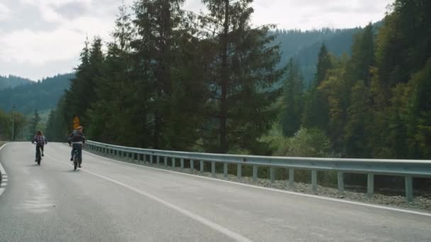 Passeios de bicicleta paisagem de montanha na floresta de verão. Amigos andar de bicicleta na estrada — Vídeo de Stock