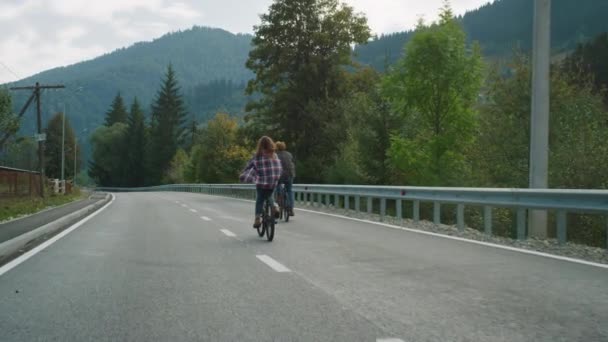 Couple riders cycling mountains together on highway road. Travelers enjoy bikes. — Stock Video
