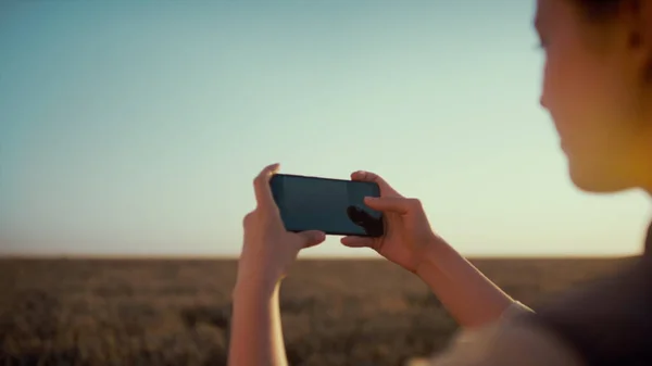 A lány vidéken fotózott. Női kéz tartsa okostelefon közelkép. — Stock Fotó