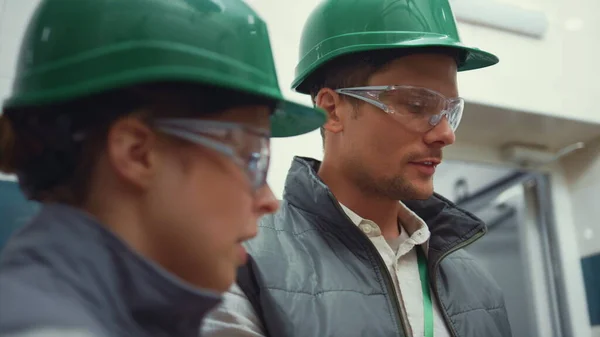Anläggningens övervakare inspekterar tillverkningen närbild. Chefer som arbetar tillsammans. — Stockfoto