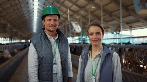 Portrait livestock team posing together modern cowshed at dairy farm facility — Foto de Stock
