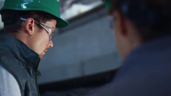 Engineer working at livestock facility closeup. Focused workers wearing uniform. — стоковое фото