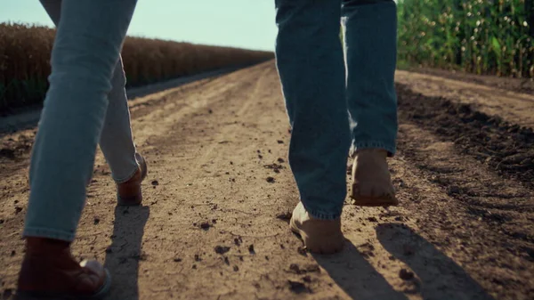 Closeup zemědělci boty chůze pozemní silnice zadní pohled. Práce v zemědělství. — Stock fotografie
