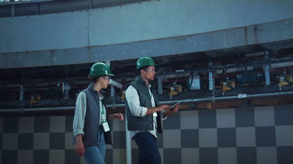 Factory workers walking at dairy room. Modern agricultural milking facility.