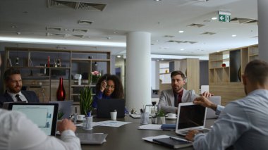 Çeşitli iş grupları toplantısı şirket masasında finansal planlar hakkında konuşuyor..
