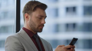 Şirket binasında telefon sörfü yapan odaklı iş adamı..