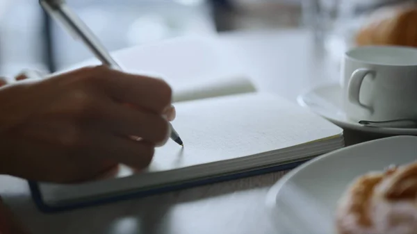 Femme prise de main notes écriture stylo ordinateur portable à distance table de café de travail. — Photo