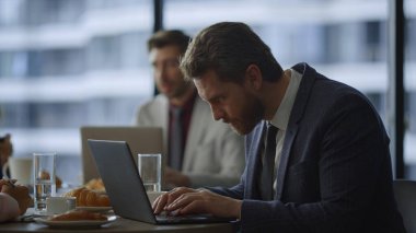 Birlikte çalışan kafede dizüstü bilgisayar keayboard 'u yazan odaklanmış serbest çalışan bir işçi..