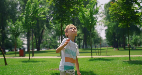 Fröhlicher Junge beim Badmintonspiel. Glückliches Kind schaut auf Federball. — Stockfoto