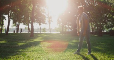 Neşeli adam köpeğini çağırıyor. Yaz şehri bahçesine gelsin diye. El vuruşu, bacak.