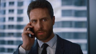 Modern finans ofisinde cep telefonuyla arama yapan odaklı girişimci.