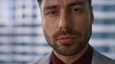 Yakışıklı iş adamı modern ofis işyerinde kameraya güvenle bakıyor..