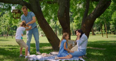 Baba piknikte küçük oğlunu geride tut. Ebeveynler yazın çocuklarla oynarlar..