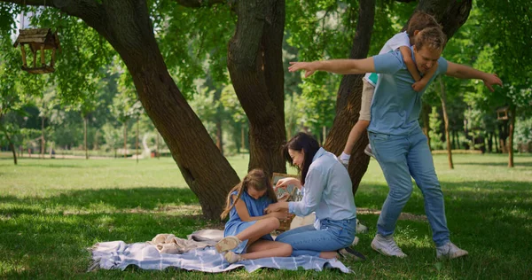 Lilla sonen har piggyback rida på lycklig far. Agile man hålla söt pojke på rygg. — Stockfoto