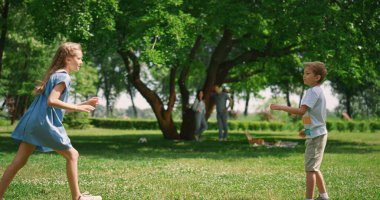 Kaygısız kardeşler güzel çimlerde kovalamaca oynarlar. Sağlıklı aktif çocukluk