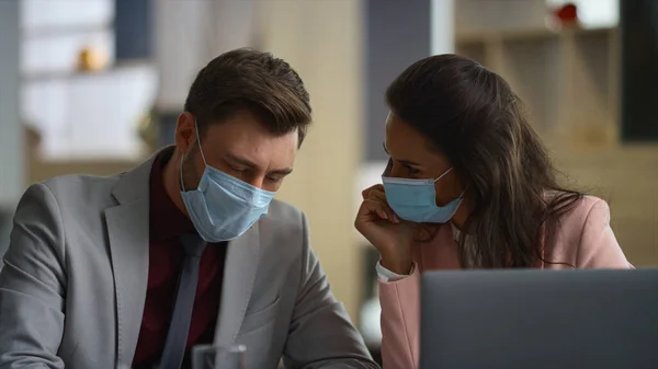 Couple business people talk wear face protection in financial workplace office.