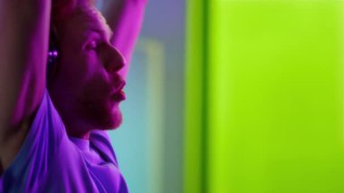 Heyecanlı oyuncu siber başarıyı kutluyor. Neşeli adam neon ışıkta bağırıyor