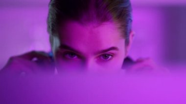 Pembe neon ışıklarla çevrilmeden önce siber kulaklık takan bir kız..