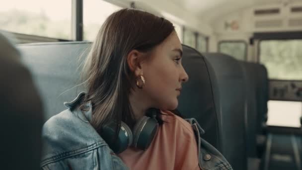 Adolescente sentada autobús escolar de cerca. Colegiala charlando con el pasajero. — Vídeos de Stock