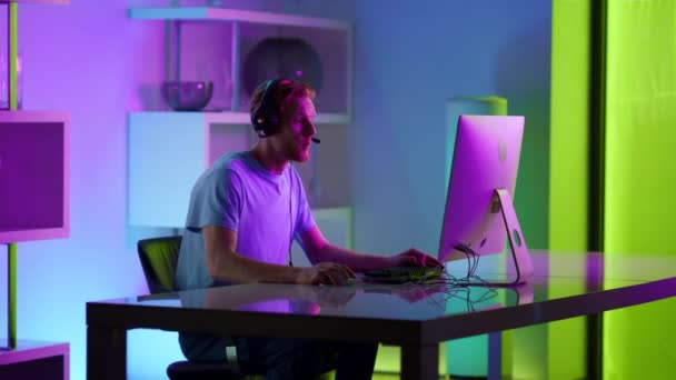 Excited man celebrating gaming tournament victory in neon cyberspace at home. — Stock Video