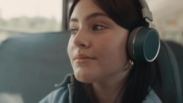 Dreamy twarz dziewczyny słuchanie muzyki ze słuchawkami zbliżenie. Uczennica uśmiechnięta. — Wideo stockowe