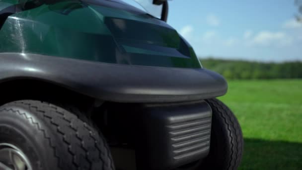 Puste pole golfowe na zewnątrz. Golf samochód buggy opony koła stoją na trawie. — Wideo stockowe