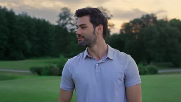 Happy model smiling outside. Handsome sportsman standing on golf course sunset. — Stock Video